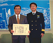 感謝状を受けた白崎船長（左）横浜海上保安部長石間氏（右）